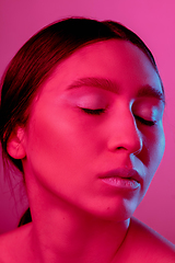 Image showing Beautiful east woman portrait isolated on pink studio background in neon light, monochrome