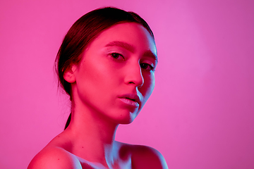 Image showing Beautiful east woman portrait isolated on pink studio background in neon light, monochrome