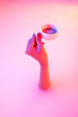 Image showing Close up female hand gesturing from the milk bath with soft glowing in neon light