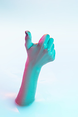 Image showing Close up female hand gesturing from the milk bath with soft glowing in neon light