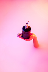 Image showing Close up female hand gesturing from the milk bath with soft glowing in neon light