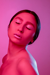 Image showing Beautiful east woman portrait isolated on pink studio background in neon light, monochrome