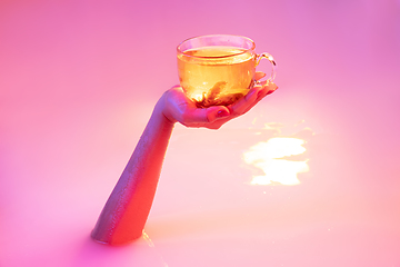 Image showing Close up female hand gesturing from the milk bath with soft glowing in neon light