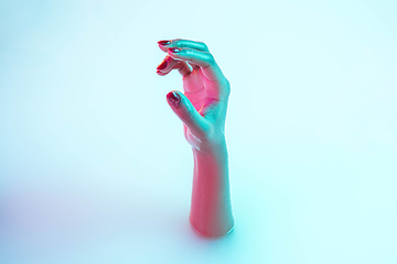 Image showing Close up female hand gesturing from the milk bath with soft glowing in neon light