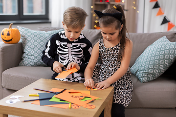 Image showing kids in halloween costumes doing crafts at home