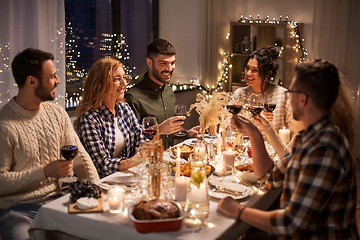 Image showing happy friends drinking red wine at christmas party