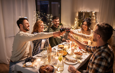 Image showing happy friends drinking red wine at christmas party