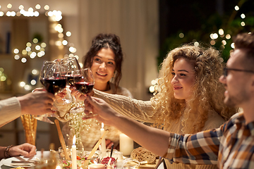 Image showing happy friends drinking red wine at christmas party