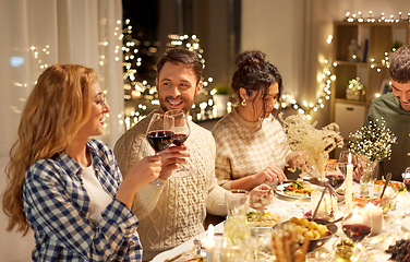 Image showing happy friends drinking red wine at christmas party