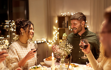 Image showing happy friends drinking red wine at christmas party