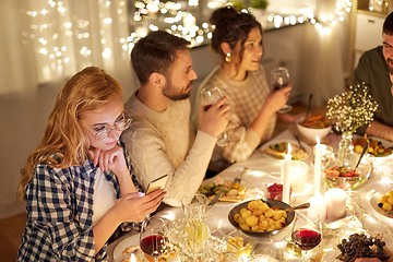 Image showing woman with smartphone at dinner party with friends