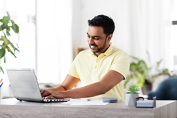 Image showing man with laptop and papers working at home