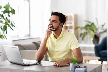 Image showing indian man with notebook and laptop at home office