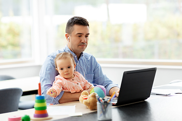 Image showing father with baby working at home office