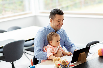 Image showing father with baby working on tablet pc at home