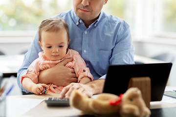 Image showing father with baby working at home