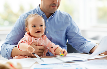 Image showing father with baby working at home office