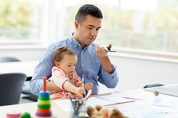 Image showing father with baby and phone working at home office