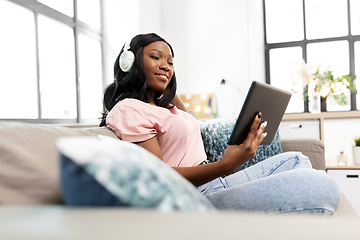 Image showing woman with tablet pc listening to music at home