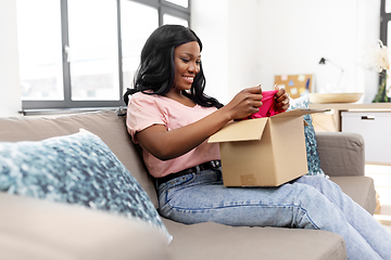 Image showing african american woman opening parcel box at home