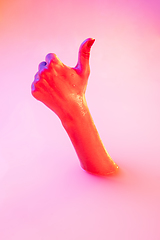 Image showing Close up female hand gesturing from the milk bath with soft glowing in neon light