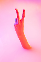 Image showing Close up female hand gesturing from the milk bath with soft glowing in neon light