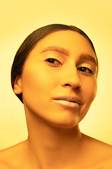 Image showing Beautiful east woman portrait isolated on yellow studio background in neon light, monochrome