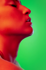 Image showing Beautiful east woman close up portrait isolated on green background in red neon light