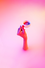 Image showing Close up female hand gesturing from the milk bath with soft glowing in neon light