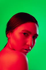 Image showing Beautiful east woman close up portrait isolated on green background in red neon light