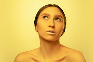 Image showing Beautiful east woman portrait isolated on yellow studio background in neon light, monochrome