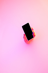 Image showing Close up female hand gesturing from the milk bath with soft glowing in neon light