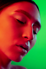 Image showing Beautiful east woman close up portrait isolated on green background in red neon light