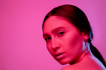 Image showing Beautiful east woman portrait isolated on pink studio background in neon light, monochrome