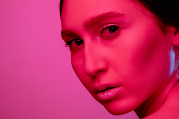 Image showing Beautiful east woman portrait isolated on pink studio background in neon light, monochrome