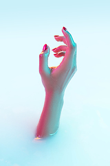 Image showing Close up female hand gesturing from the milk bath with soft glowing in neon light