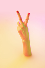 Image showing Close up female hand gesturing from the milk bath with soft glowing in neon light