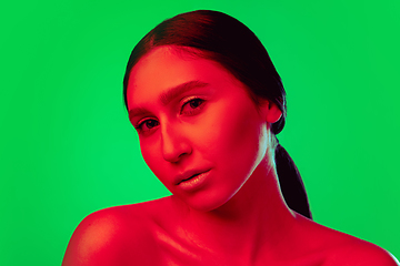 Image showing Beautiful east woman close up portrait isolated on green background in red neon light