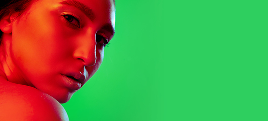 Image showing Beautiful east woman close up portrait isolated on green background in red neon light