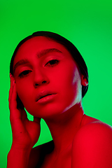 Image showing Beautiful east woman close up portrait isolated on green background in red neon light