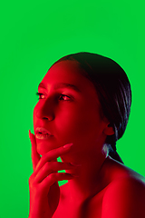 Image showing Beautiful east woman close up portrait isolated on green background in red neon light