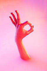 Image showing Close up female hand gesturing from the milk bath with soft glowing in neon light