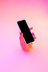 Image showing Close up female hand gesturing from the milk bath with soft glowing in neon light