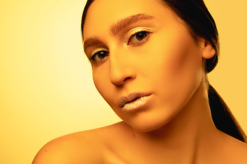 Image showing Beautiful east woman portrait isolated on yellow studio background in neon light, monochrome