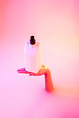 Image showing Close up female hand gesturing from the milk bath with soft glowing in neon light