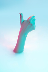 Image showing Close up female hand gesturing from the milk bath with soft glowing in neon light