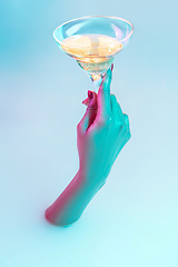 Image showing Close up female hand gesturing from the milk bath with soft glowing in neon light