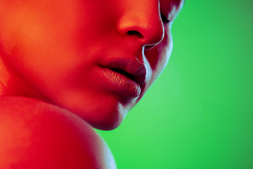 Image showing Beautiful east woman close up portrait isolated on green background in red neon light