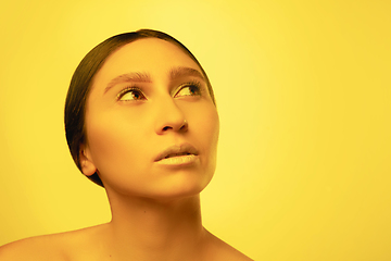 Image showing Beautiful east woman portrait isolated on yellow studio background in neon light, monochrome
