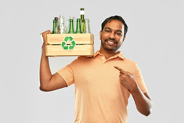 Image showing smiling young indian man sorting glass waste